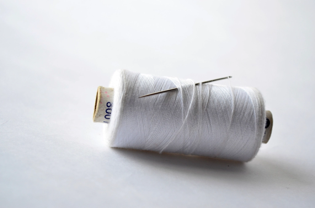White thread cone wound on a paper tube core